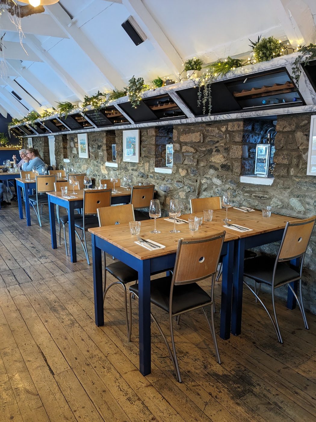 The dining room: wooden tables under a glass roof